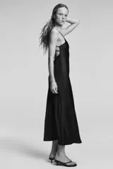 Vestido midi de tejido satinado color celeste pálido, con escote en V y tirantes finos ajustables. Presenta un detalle de tiras cruzadas en la espalda.