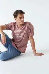 Remera color ladrillo con estampado frontal con la leyenda "BROOKSFIELD CLASSIC BRAND COMPANY TRADE MARK BASED IN TORINO - ITALY - ROAD MARKET EST 1971 REG TM".