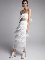 Conjunto de top bandeau y falda midi, ambos blancos con flecos.