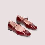 Ballerinas Mary Jane color burdeos charolado, con punta cuadrada, tira sobre el empeine con hebilla dorada y plantilla de cuero acolchada.
