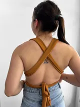 Top negro con escote halter y tiras cruzadas en el abdomen.