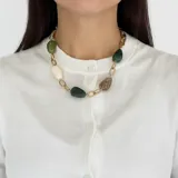 Collar de cadena de eslabones dorados en acero, intercalados con cuentas de resina en tonos verdes, beige y marrón. Cuenta con cierre de mosquetón ajustable.