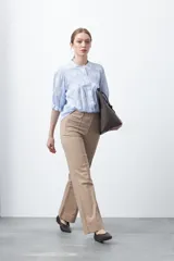 Pantalón de mujer color beige, de corte recto y tiro alto, con costuras frontales marcadas que recorren la pierna.