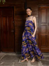 Vestido largo de corte holgado con estampado abstracto en tonos violeta, azul y amarillo. Presenta breteles finos regulables, escote recto y bolsillos laterales. Incluye un accesorio tipo choker a juego y cuenta con forro interior corto.