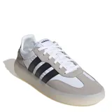 Championes Adidas Barreda Decode de estilo retro, con diseño inspirado en el calzado de fútbol. Presentan una combinación de paneles de tela blanca, refuerzos de gamuza gris en la puntera y el talón, y las icónicas tres tiras laterales en color negro. Cuentan con una mediasuela translúcida y suela de goma para mayor tracción.