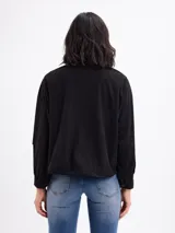 Campera de pana negra con cierre frontal de botones metálicos, cuello clásico y dos bolsillos frontales con solapa. Presenta mangas largas con puños abotonados y un diseño liviano sin forro.