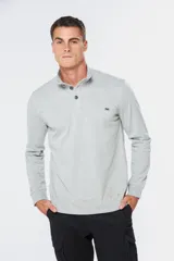 Remera de manga larga tipo buzo liviano, confeccionada en tejido jersey color gris melange. Presenta cuello mao con tapeta de tres botones y puños en rib.