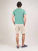 Bermuda cargo de corte regular fit en color azul marino, confeccionada en algodón. Cuenta con cintura elástica con cordones ajustables y bolsillos laterales tipo cargo en las piernas.