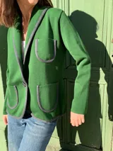 Blazer verde de tejido de punto, con solapas con borde gris, cierre con un botón y bolsillos de parche.