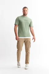 Remera verde militar de algodón, con cuello redondo y estampado con texto en el pecho.