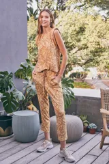 Pantalón de tiro alto con estampado paisley en tonos maíz y tierra, confeccionado en tejido fluido. Presenta cintura elástica con cordón ajustable y bolsillos laterales.