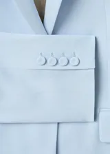 Blazer celeste de corte recto, con cuello de solapa con muesca, manga larga, bolsillos laterales con solapa y cierre frontal de un botón.