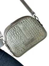Bandolera Chabas modelo Baby de cuero natural con textura en relieve tipo cocodrilo, color dorado. Cuenta con cierre de metal, correa de cuero regulable y detalle de placa metálica con la marca grabada en el frente.