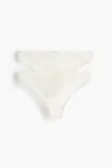 Pack de dos bombachas tipo colaless confeccionadas en encaje color blanco, con cintura de tiro medio y pequeño lazo decorativo al frente.