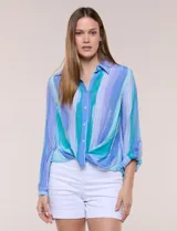 Blusa de gasa blanca con estampado floral multicolor, cuello con solapa, cierre frontal de botones y diseño anudado en la parte delantera.