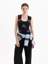 Top sin mangas de algodón negro con estampado de alfileres de gancho y fresas. Presenta escote cuadrado con detalle de puntilla y un pequeño moño central.