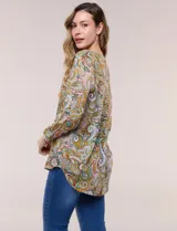 Blusa holgada de rayón con estampado de arabescos en tonos marrón, mostaza, rosado y celeste. Presenta escote en V con cuello mao, mangas tres cuartos y dobladillo asimétrico.