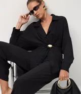 Pantalón de corte recto confeccionado en tejido satinado de viscosa y poliéster. Presenta pliegues delanteros marcados, cintura con trabillas y bolsillo trasero incorporado.