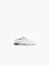Zapato de cuero vacuno color blanco con acabado arrugado, diseño estilo oxford con detalles perforados, cordones y tacón bajo decorado con pedrería.