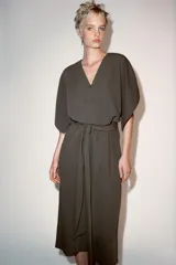 Vestido midi ZW Collection de color verde militar, con escote en pico, mangas anchas por debajo del codo y cierre frontal con alamares. Cuenta con un cinturón del mismo tejido para anudar en la cintura y bajo acabado en línea evasé.