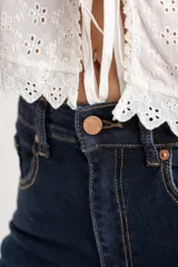 Jean de corte flare y tiro medio, con diseño de pierna ancha y ruedo desflecado. Confeccionado en denim de tono azul oscuro.