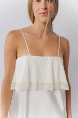 Camisón corto de satén elastizado color blanco, con escote recto y detalle de volado con puntilla en el pecho. Posee breteles finos regulables.