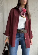 Sobrecamisa de pana color bordó, con cuello camisero, cierre frontal de botones y mangas largas con puños. Presenta una textura acanalada característica de la pana.