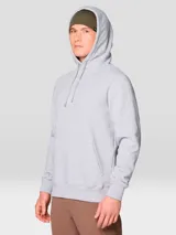 Buzo tipo canguro con capucha y cordones ajustables, confeccionado en mezcla de algodón. Presenta un diseño liso de color gris melange con bolsillo frontal tipo canguro y logo de la marca bordado en el centro del pecho.