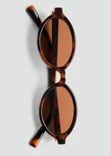Lentes de sol con montura ovalada de pasta con estampado carey y cristales marrones.