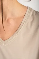 Remera de algodón peinado color marfil, de manga corta y corte al cuerpo, con escote en V ribeteado con hilo dorado.