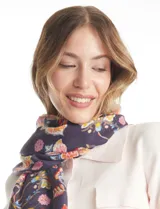 Pashmina estampada con diseño floral multicolor sobre fondo blanco, con terminación deflecada en los bordes.