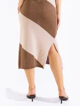 Vestido midi de punto sin mangas con diseño de rayas diagonales bicolor en tonos azul y celeste, escote bote y aberturas laterales en el dobladillo.
