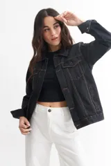 Campera de jean celeste con cuello clásico, cierre frontal con botones metálicos negros, bolsillos con solapa abotonada en el pecho y mangas largas con puños abotonados.