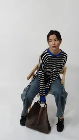 Remera de manga larga con diseño a rayas horizontales en blanco y negro, destacada por su cuello redondo y puños en color azul vibrante. Presenta un corte relajado y cómodo.