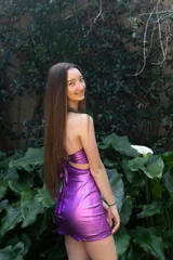 Vestido corto de fiesta color lila metalizado, con escote en V, breteles finos, cut-outs en la cintura y falda ajustada con cordones laterales.