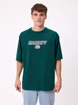 Remera de corte holgado color gris melange, con mangas raglán y estampado frontal con el logo de la marca Rusty en tonos azul y rojo.