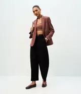 Pantalón de sastrería en crepé color negro con modelaje barrel, cintura estructurada con pasadores y piernas amplias con ruedo levemente afinado.