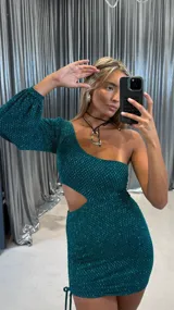 Vestido corto verde brillante con un hombro descubierto y una manga larga abullonada. Presenta un corte en la cintura y fruncido ajustable con cordón en un lateral de la falda.