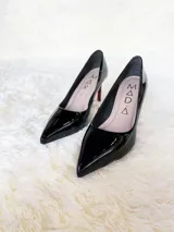 Zapatos de tacón alto con textura de reptil, color negro, con suela roja característica.