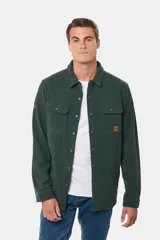 Camisa azul marino de poliéster con textura polar, corte recto, cuello camisero, cierre frontal con botones a presión, dos bolsillos de parche con solapa abotonada en el pecho y puños abotonados.