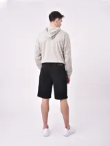 Bermuda de denim color negro, corte recto con dobladillo en el borde inferior y bolsillos clásicos.