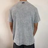 Remera de algodón con efecto lavado (acid wash) en color gris oscuro, de corte regular y cuello redondo.