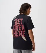 Remera negra de algodón con cuello redondo y mangas cortas, de corte comfort. Presenta una gran estampa en la espalda con la frase "Get Over Here" y un diseño gráfico de la lanza de Scorpion de Mortal Kombat.
