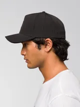 Gorro tipo gorra con visera curva de color negro, con el logo de CAT impreso en relieve en la parte delantera.