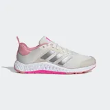 Championes deportivos Adidas Everyset Trainer, color blanco hueso con detalles en rosa claro y tres franjas laterales plateadas. Presentan una entresuela de doble densidad con detalles texturizados y suela exterior en color rosa vibrante.