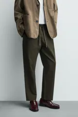 Pantalón de corte relajado confeccionado en una mezcla de algodón y lino. Presenta cintura elástica con cordón ajustable, bolsillos laterales y bolsillos traseros de vivo.