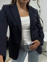 Blazer sastrero de corte clásico en color azul marino, con solapas de muesca, cierre frontal de un botón y bolsillos laterales con solapa.