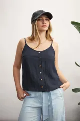 Musculosa color azul marino con escote en V y botones dorados en el frente. La tela presenta una textura arrugada o plisada.