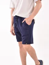 Bermuda negra con textura acanalada horizontal, corte a la rodilla y cintura con cordón ajustable.