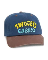 Gorra tipo dad cap azul con visera marrón de contraste, con lettering bordado en la parte frontal con las palabras "TwoJeys" en amarillo y "Cabrio" en celeste.